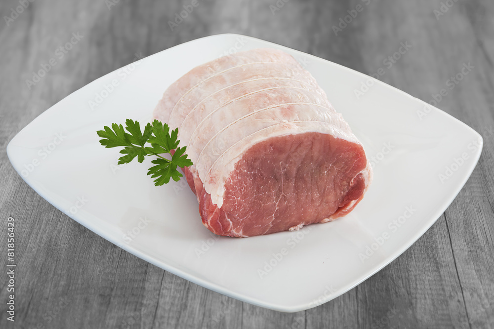 roti de filet de porc cru sur assiette blanche roti de filet de porc cru sur assiette blanche