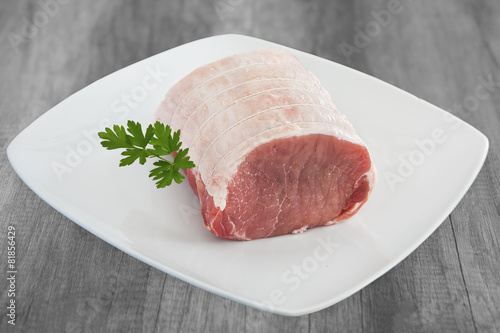 roti de filet de porc cru sur assiette blanche