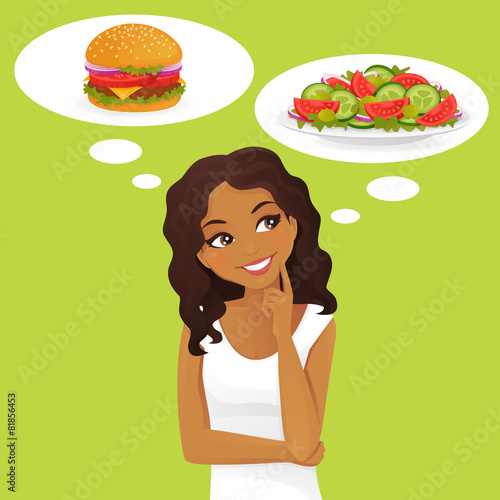 Beautiful black woman choosing between salad and hamburger