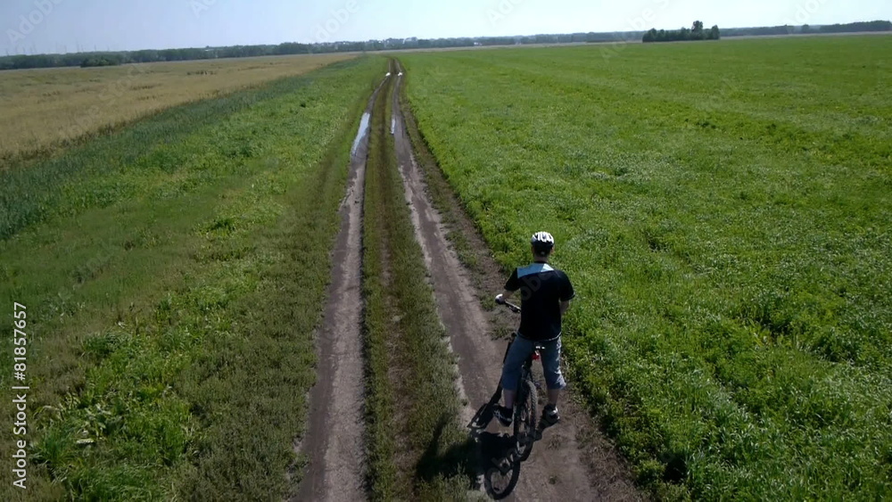 Man cycling on a rural road. Aerial view. Man cycling on a rural road. Aerial view.