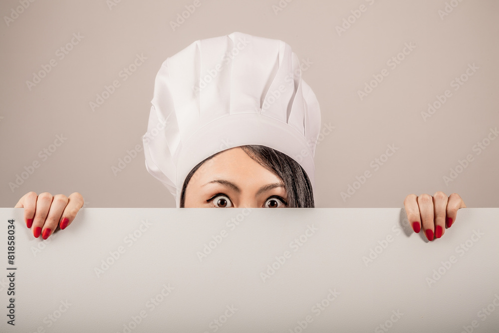 Young woman chef holding a blank white sign Young woman chef holding a blank white sign
