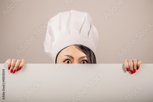 Young woman chef holding a blank white sign photo