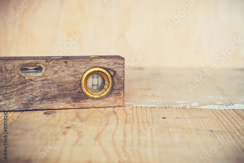 Old vintage spirit level on wooden background