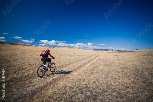 Young girl riding a bicycle in the mountains.