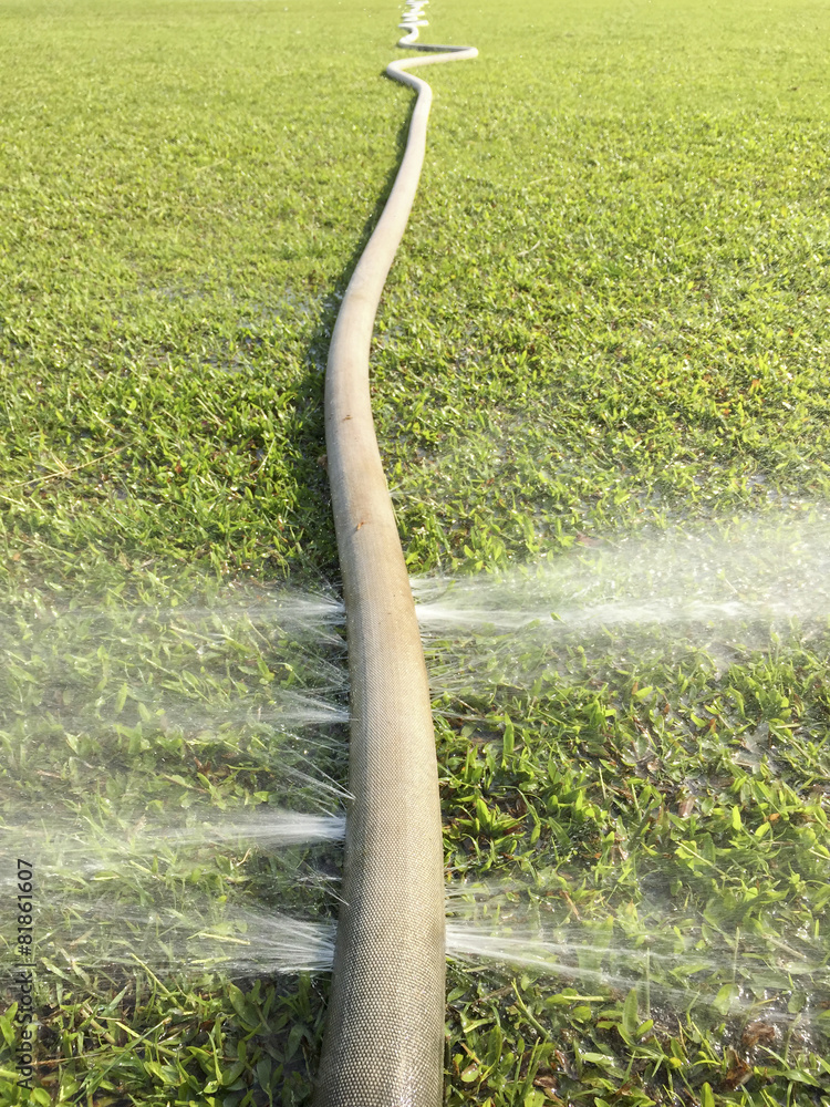 Fototapeta premium wasting water - water leaking from hole in a hose