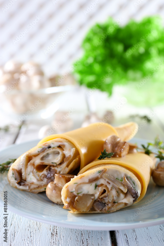 Pancakes with cream and mushrooms on wooden table, closeup Pancakes with cream and mushrooms on wooden table, closeup