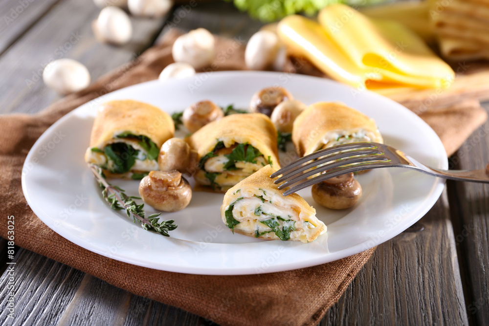 Pancakes with creamy mushrooms in plate on wooden table, closeup Pancakes with creamy mushrooms in plate on wooden table, closeup