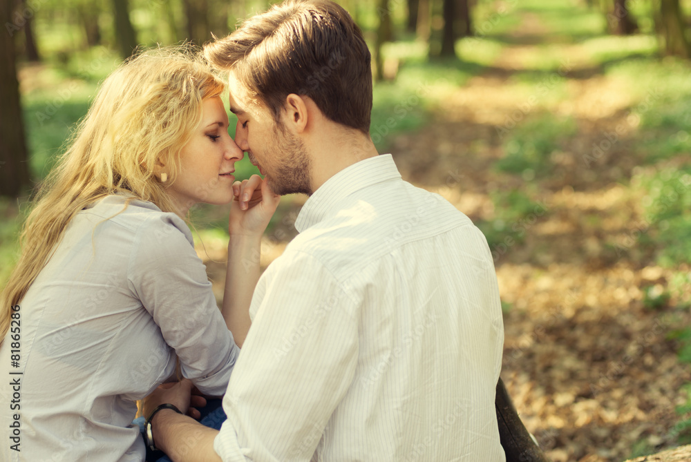 Kiss beautiful romantic couple in a park in spring Kiss beautiful romantic couple in a park in spring