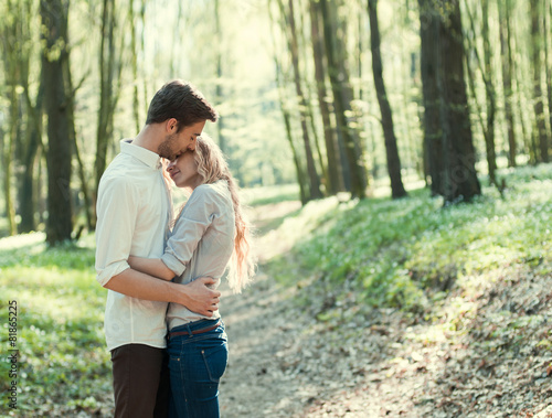 beautiful young couple kissing in the park in spring