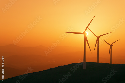 wind turbines silhouette on mountain at sunset photo