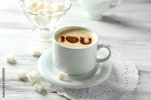 Cup of latte coffee art on wooden table  on light background