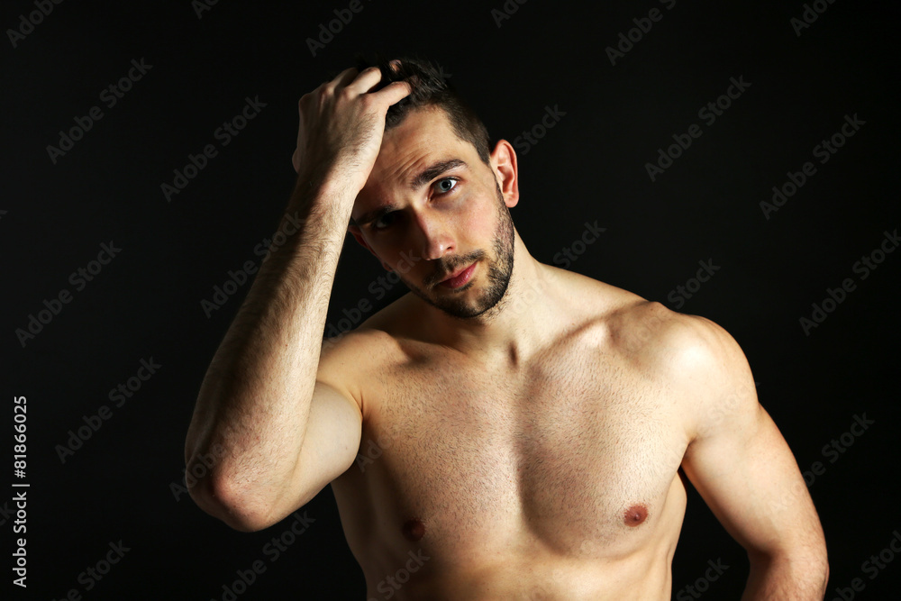 Fototapeta premium Muscle young man on black background