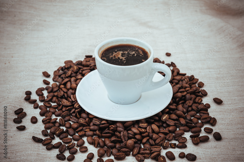 Cup of coffee and roasted beans on beige background Cup of coffee and roasted beans on beige background