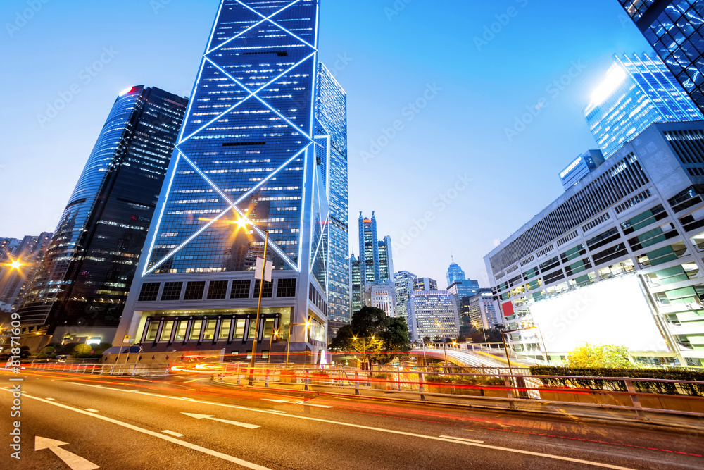 traffic light trails and office buildings in modern city