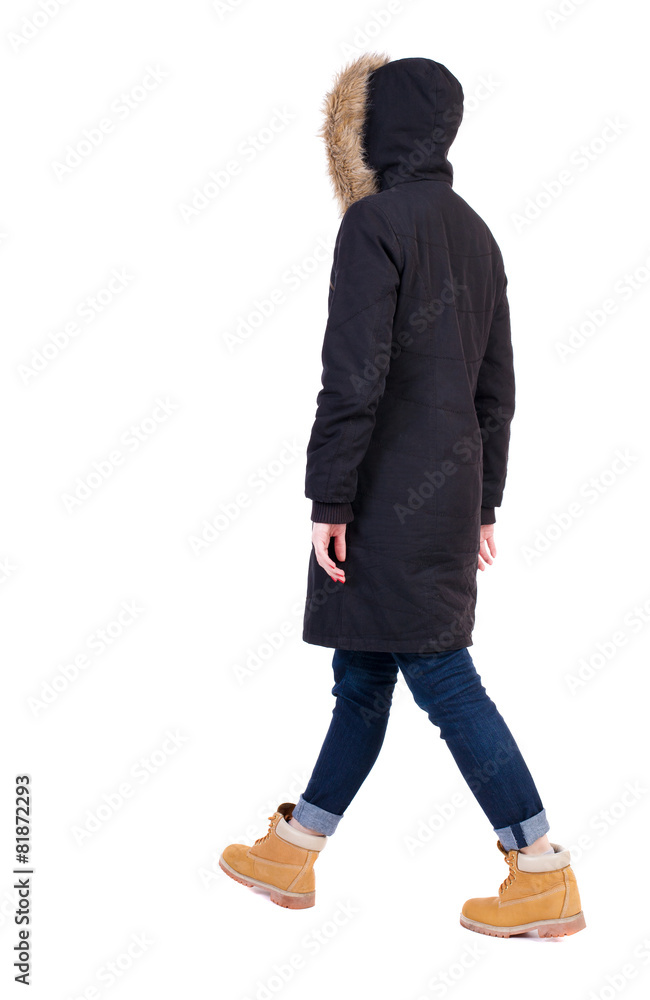 Naklejka premium Back view of going woman in parka.