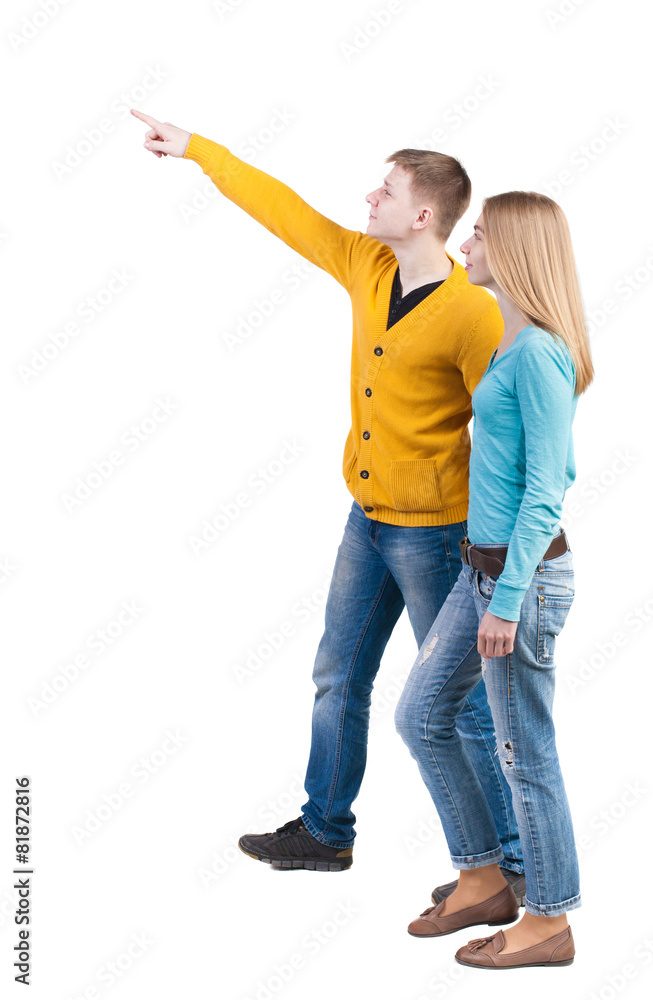 Back view of walking young couple (man and woman) pointing. Back view of walking young couple (man and woman) pointing.