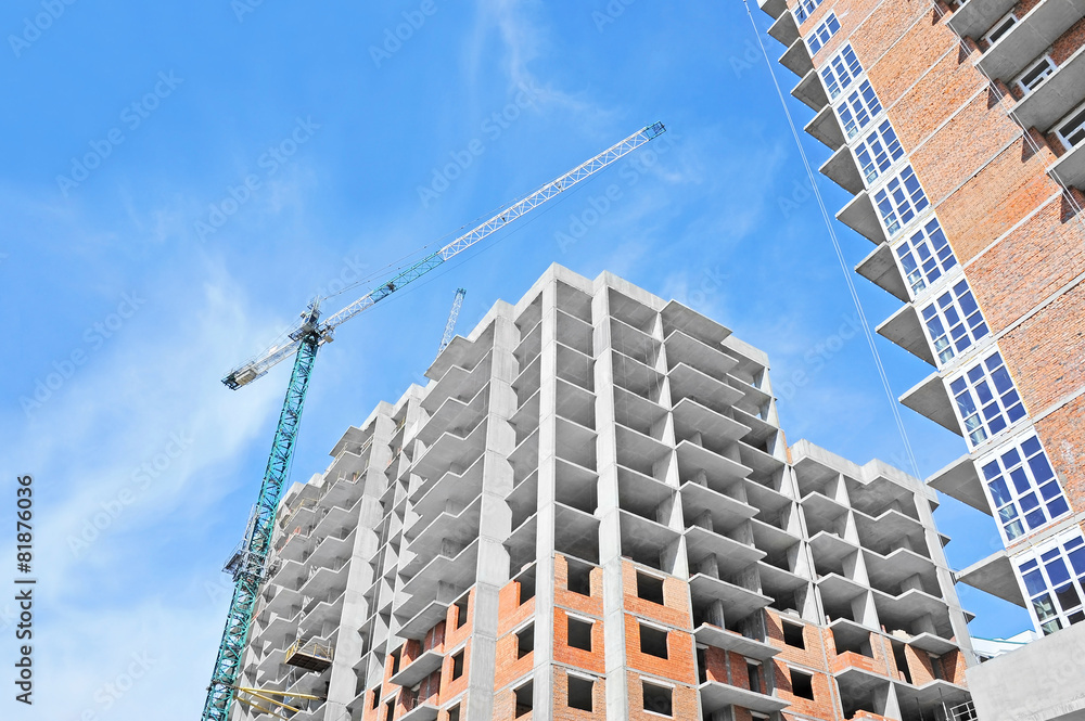 Fototapeta premium Crane and building construction site against blue sky