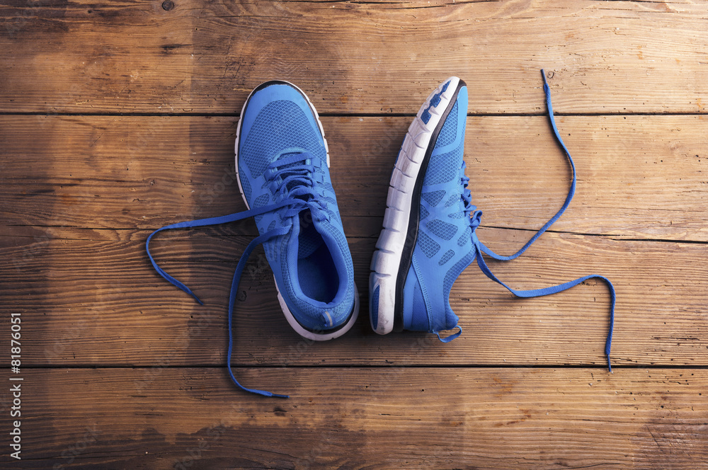 Pair of blue running shoes laid on a wooden floor background Stock Photo |  Adobe Stock
