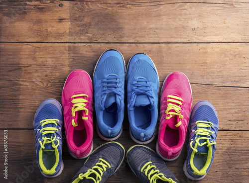 Various running shoes laid on a wooden floor background