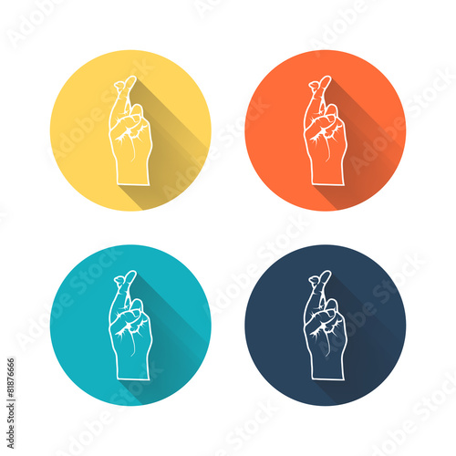 Human hand with crossed fingers and long shadow.