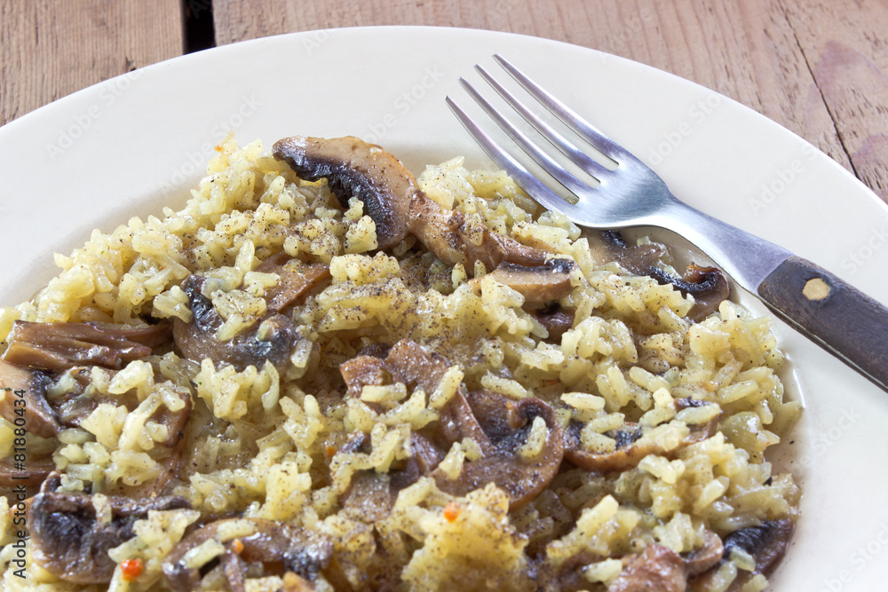 Risotto with mushrooms on plate with fork
