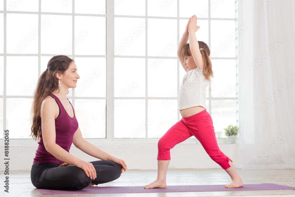Young mother and daughter doing yoga exercise Young mother and daughter doing yoga exercise
