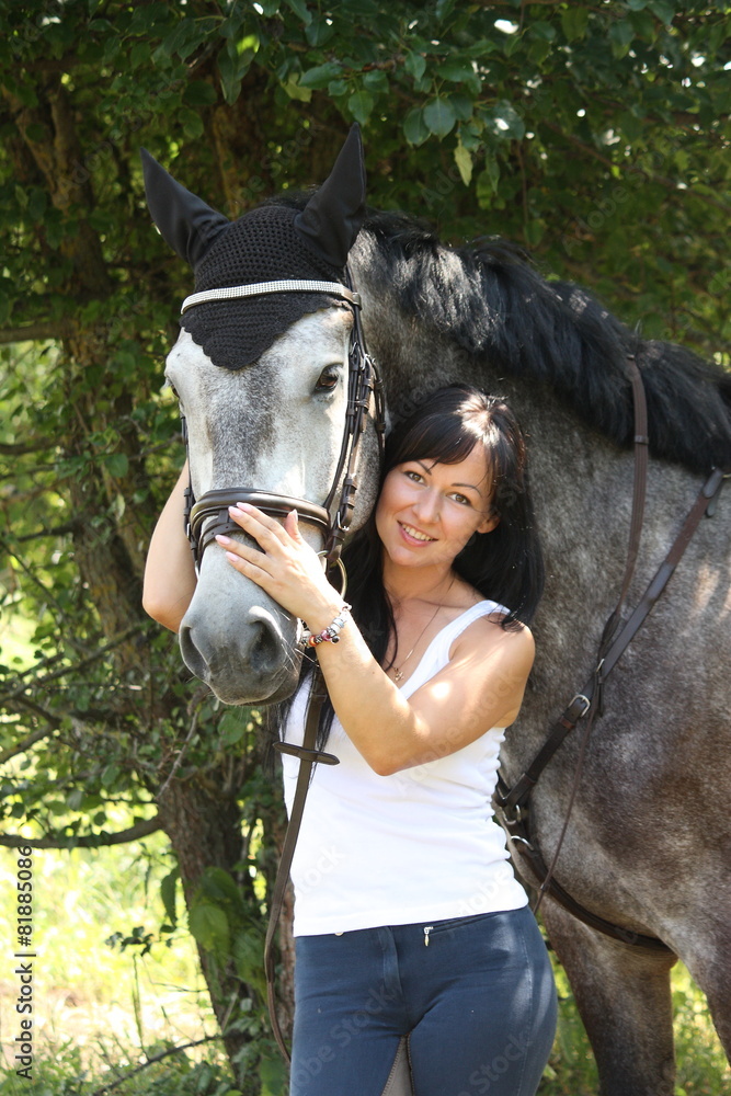 Naklejka premium Portrait of beautiful woman and gray horse in garden