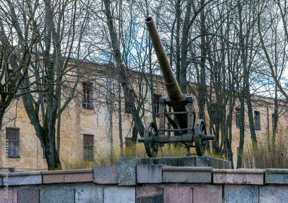 Fototapeta premium Old metal cannon on a stone wall