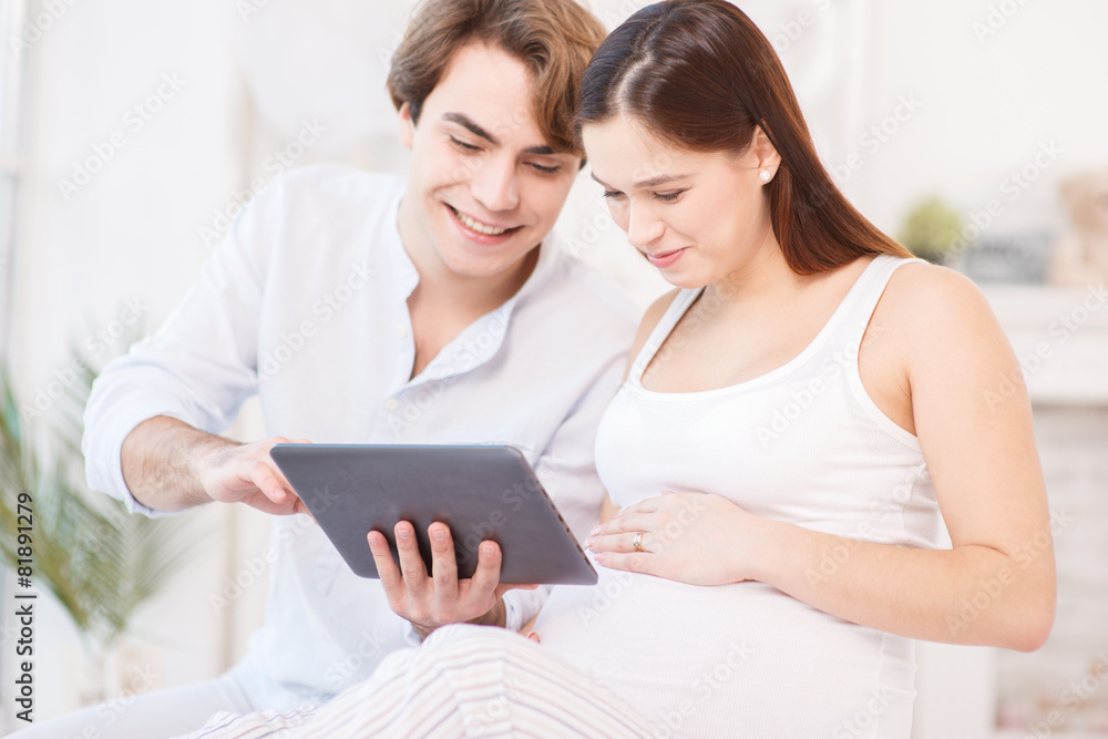 Pregnant woman using tablet computer with her husband Pregnant woman using tablet computer with her husband