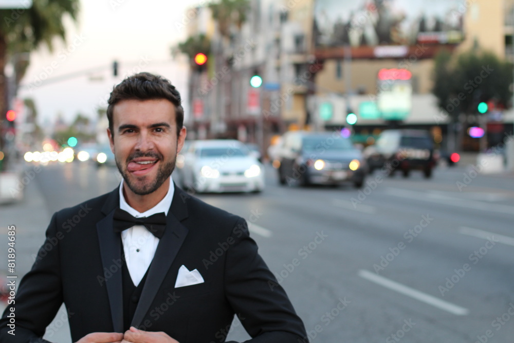 Elegant man in a tuxedo showing his tongue