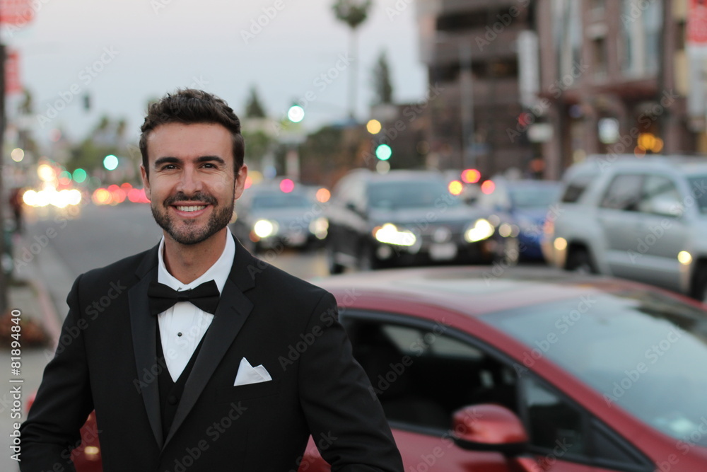 Handsome man smiling wearing an elegant tuxedo in the city