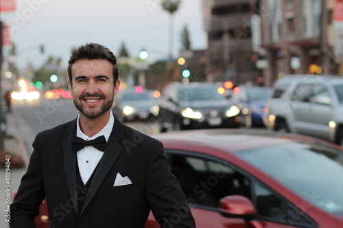 Handsome man smiling wearing an elegant tuxedo in the city © ajr_images
