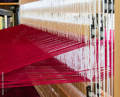 Obraz na płótnie A loom set up with red wool warp threads ready for weaving