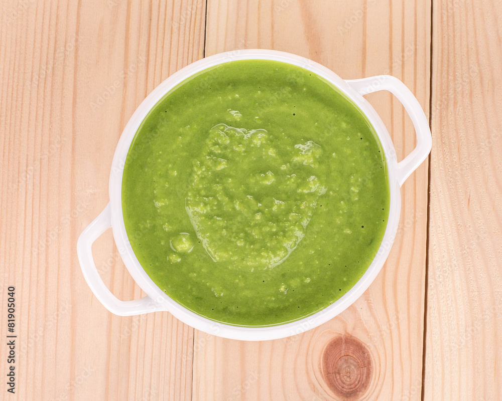 Broccoli cream soup on wood.