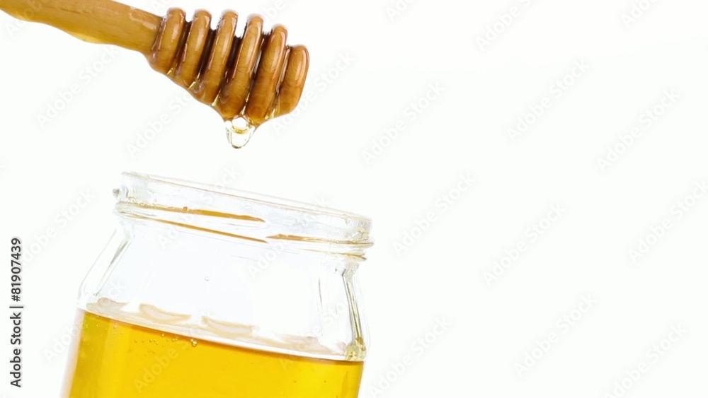 opened honey jar with wooden honey dipper on white opened honey jar with wooden honey dipper on white