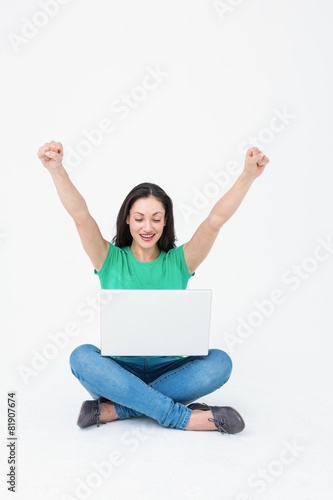 Happy brunette cheering in front of her laptop © WavebreakMediaMicro