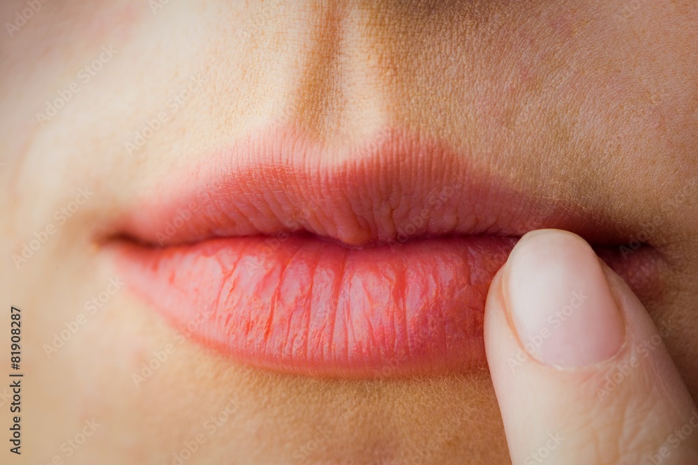 Fototapeta premium Woman pointing to her lips