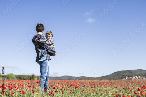 Mother and her little child having fun in a field  flower in for