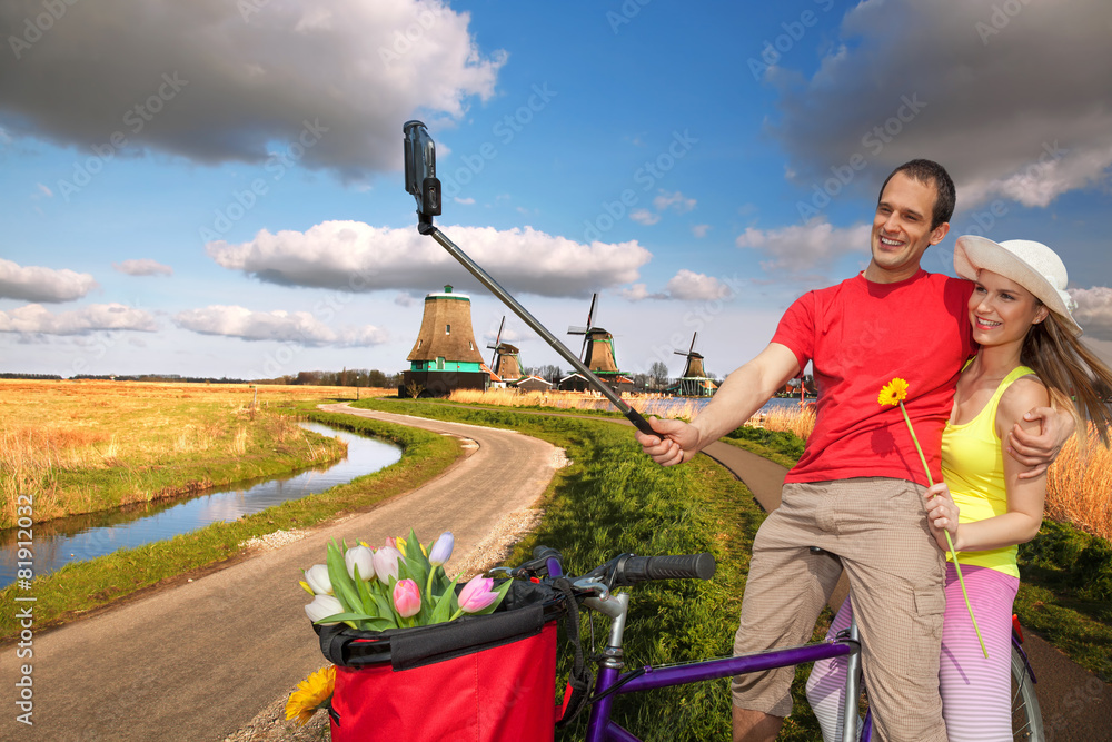 Obraz premium Couple taking Selfie against windmills near Amsterdam