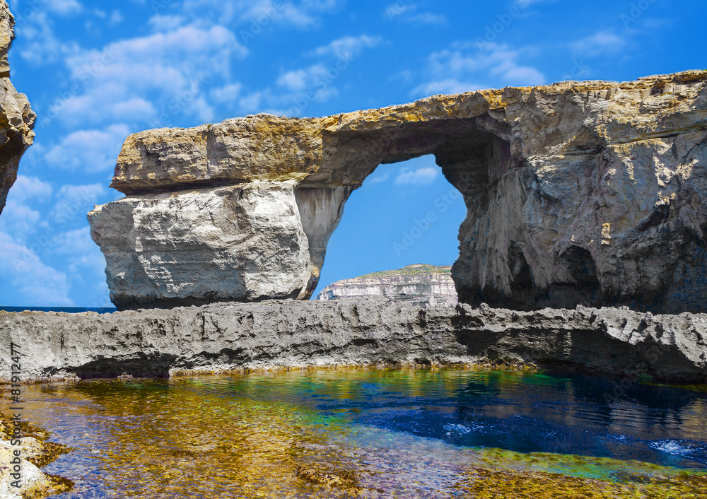 Window, famous stone arch of Gozo island in the sun in summer