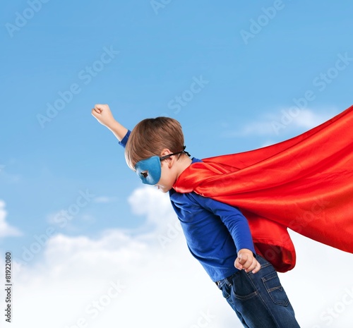 Kid. Superhero kid against blue sky background. Girl power