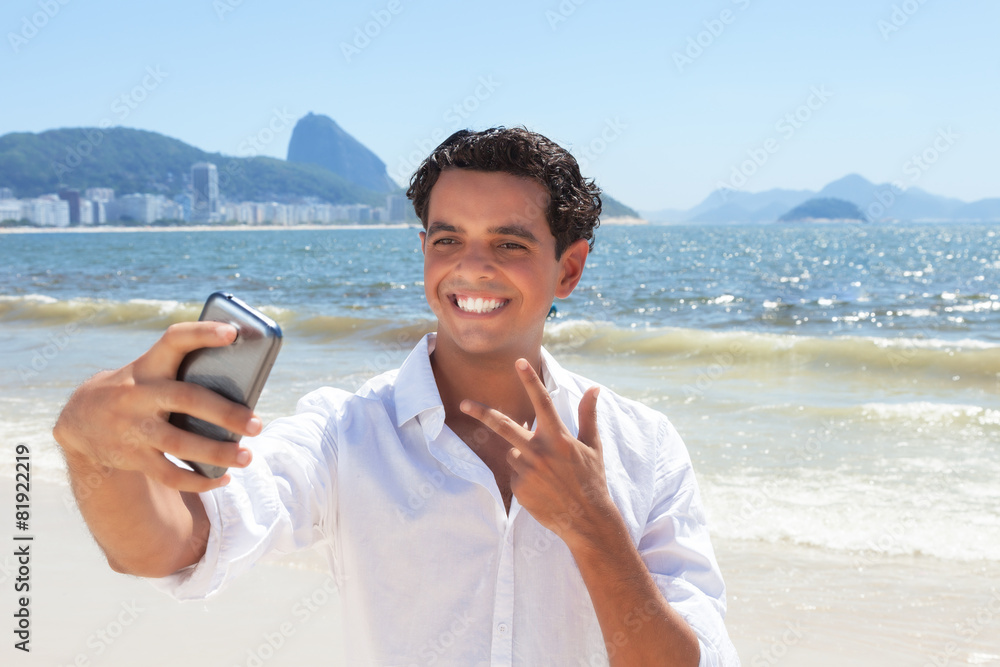 Fröhlicher junger Mann macht ein Selfie an der Copacabana
