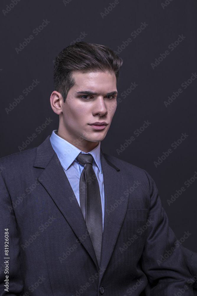 Young businessman posing in suit on a black background Young businessman posing in suit on a black background
