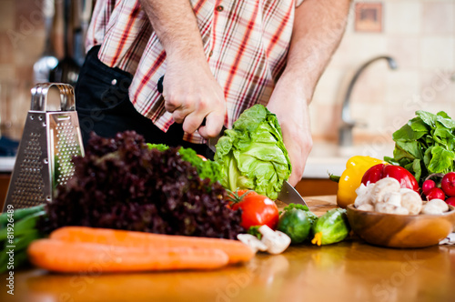 Man cuts fresh spring vegetables