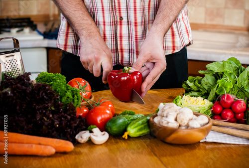 Man cuts fresh spring vegetables