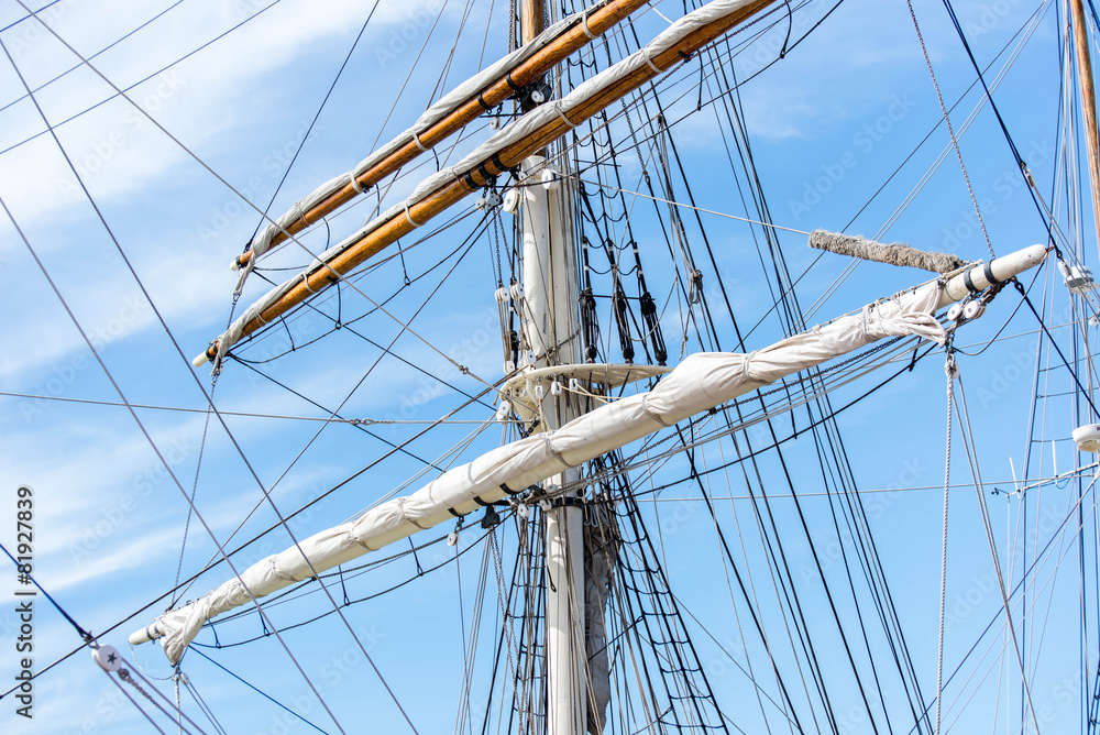 sailboat masts, rigging and rolled up sails sailboat masts, rigging and rolled up sails