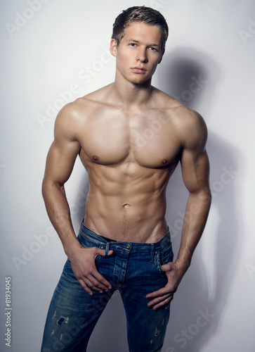 handsome young bodybuilder showing of his fit body and muscles