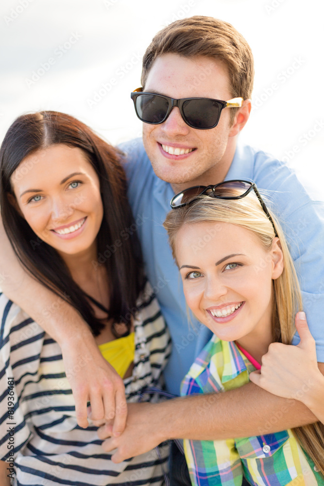 group of happy friends hugging over sky background group of happy friends hugging over sky background