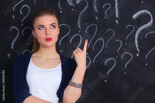 Young girl with question mark on a gray background