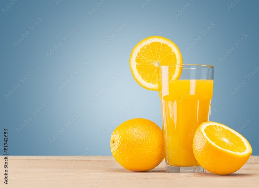 Naklejka premium Background. Fresh orange juice on wooden table over grunge